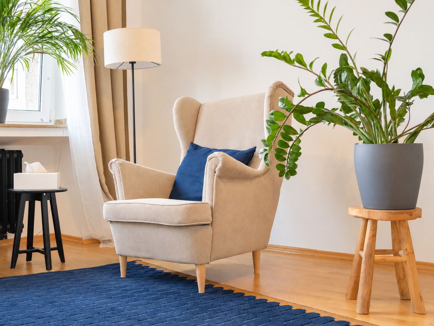 Sessel mit blauem Kissen und Pflanze im Behandlungsraum